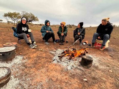 Sitting by the campfire while dinner cooks on the hot coals of the fire