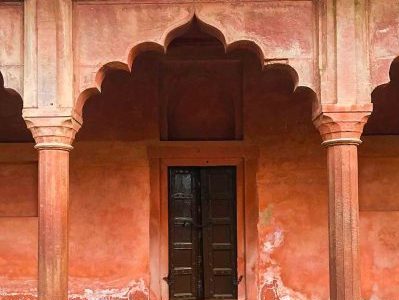 Women's India Wellbeing Journey. Close-up of one of the shuttered window archways of the Pink City, Jaipur, Rajasthan. A symbol for wellness and hospitality.
