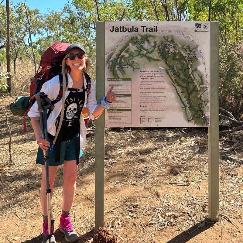 Hiker standing next to sign at the trailhead for the Jatbula Trail along the Arnhem Land escarpment.