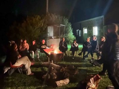 Mums and daughters around a campfire at night